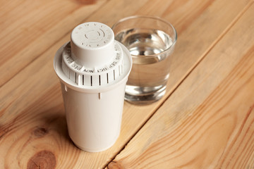 filter for cleaning tap water for drinking and a glass of filtered clean water