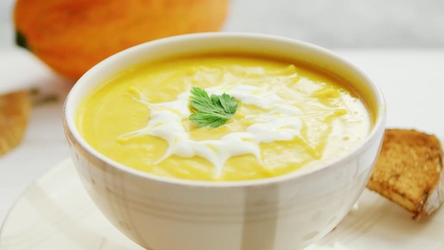 Pumpkin soup in bowl served with bread