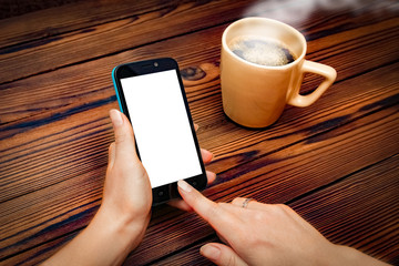 Female hands holding cup of coffee on wooden background