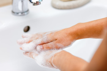 Hygiene concept. Washing hands with soap under the faucet with water
