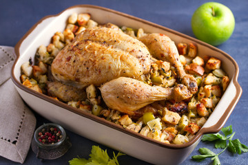 Roasted chicken with apple and bread stuffing in baking dish