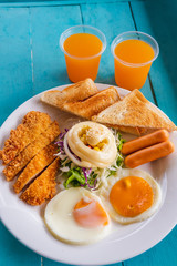 English breakfast - toast, egg, bacon and vegetables on blue wood table background