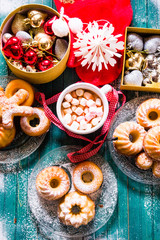 Hot marshmallow chocolate and Spiced Bundt cakes  top view with christmas decorations, a red christmas socks, small baubles and other decorations, christmas food concept image, holiday at home.