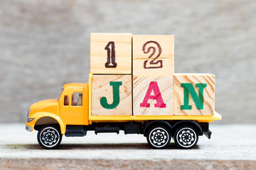 Truck hold letter block in word 12jan on wood background (Concept for date 12 month January)