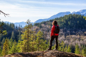 Adventurous Girl Hiking in the mountains during a sunny Autumn Evening. Taken Squamish, North of...