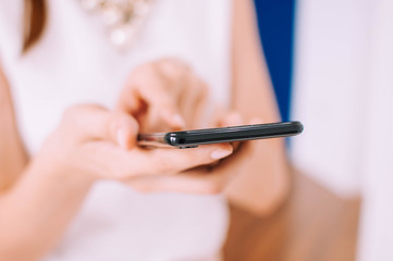 A young woman is using a smartphone indoor