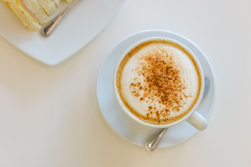 Top view of cup of hot cappuccino coffee with sandwiches for breakfast in the morning.