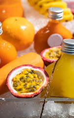 Mixed juice of passion fruit, orange, apple and carrot in plastic bottles sold on stall in shop.