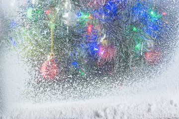 Fototapeta premium Frosted window with Christmas tree behind it.