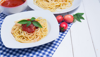 Spaghetti pasta with and tomato sauce on wood background