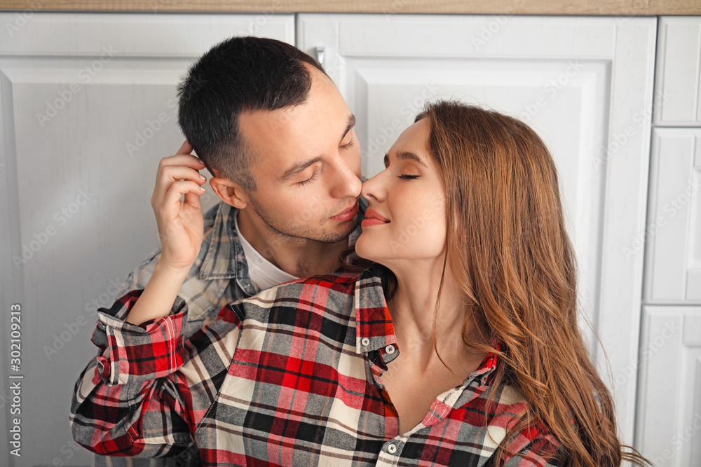 Wall mural portrait of happy young couple in kitchen