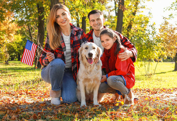 Happy family with national flag of USA in park. Memorial Day celebration