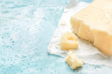 Tasty Parmesan cheese on color background, closeup