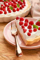 Plate with piece of tasty raspberry pie on table