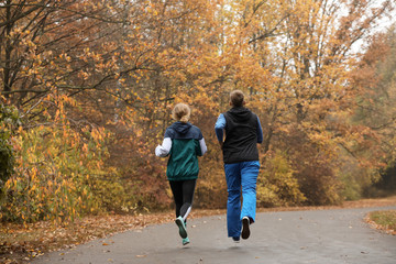 Fototapeta premium Young couple running in autumn park