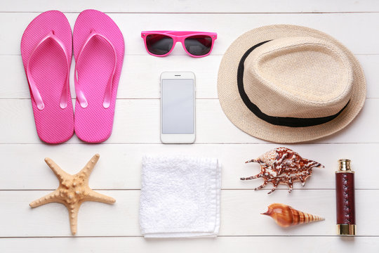 Composition with beach accessories on white wooden background