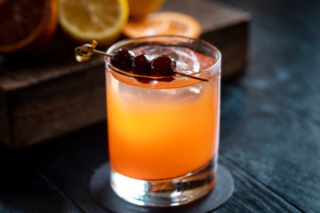 fresh cherry alcohol cocktail at a restaurant interior on a dark wooden background 