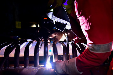 Welder is assembling Hydro-Grate tube to pipe header in the furnace of boiler with Tungsten Inert...