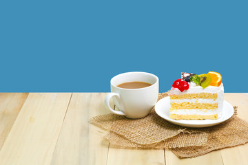 Slice cake with coffee cup on wood ,  blue background