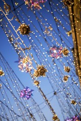City street is decorated for New Year and winter holidays. Christmas lights. Festive decorations, illumination and vintage lamps on the street at night.