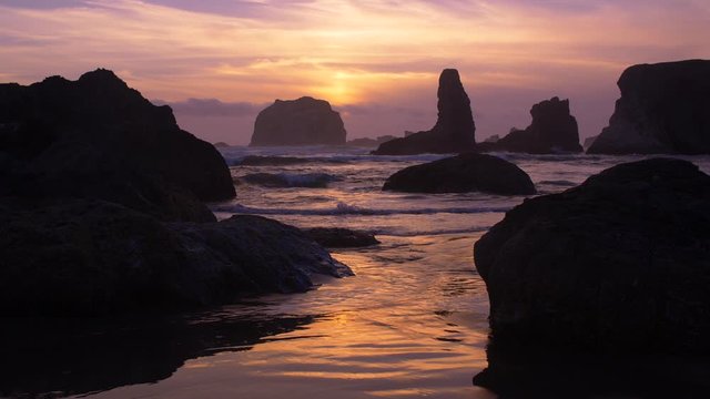 As surreal sunset dances off the waves on a rugged beach coastline