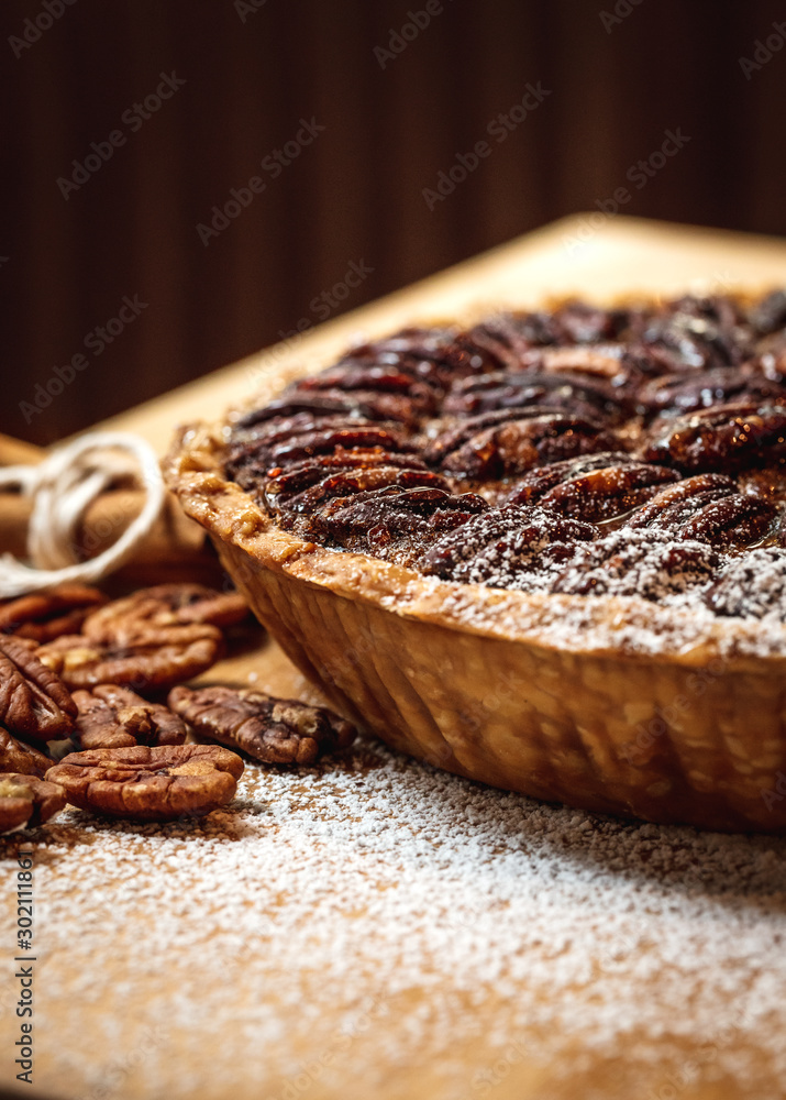 Wall mural Fresh baked maple walnut pecan pie on a brown wooden background - Wall murals