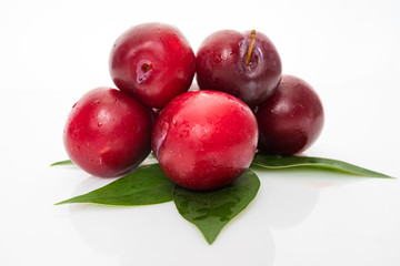 plums with plum leaves on a white background