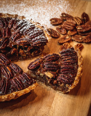Fresh baked maple walnut pecan pie on a brown wooden background