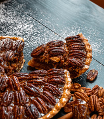 Fresh baked maple walnut pecan pie on a dark wooden background