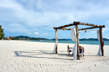 Langkawi, Malaysia - October 12, 2019. Romantic table with chair at Cenang beach on langkawi - obrazy, fototapety, plakaty