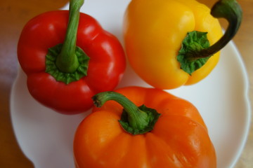 白い皿の上の3色のパプリカ