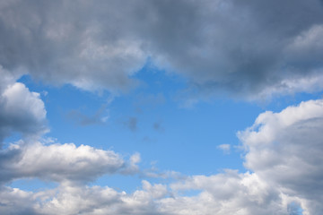 Naklejka na ściany i meble Nature background, blue sky framed by white and gray puffy clouds