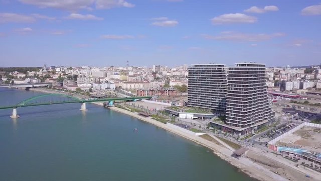 Slow panorama aerial shot of Belgrade Waterfront towers and Old train bridge on Sava river