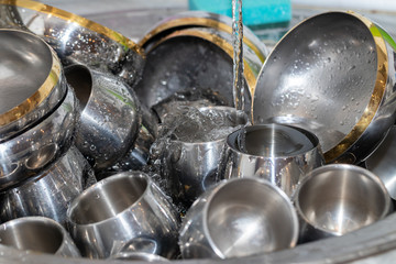 Abstract background. Mountain metal dishes in the sink. Steel bo
