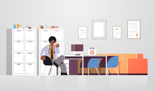male doctor in white coat having coffee break medicine healthcare concept african american medical worker sitting at workplace modern hospital clinic office interior full length flat horizontal vector
