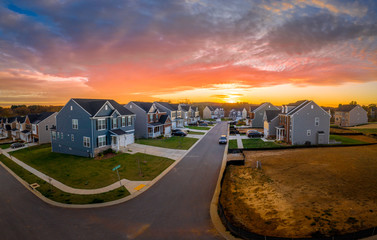 Aerial view of new construction cul-de-sac street with luxury houses in a Maryland upper middle class neighborhood American real estate development in the USA with stunning sunset orange color sky