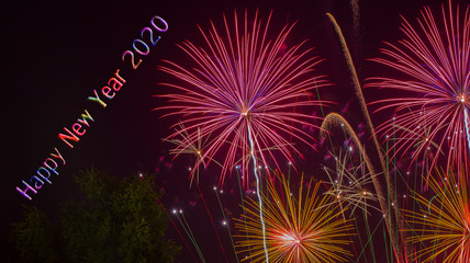 Fireworks in the night sky with word Happy New Year 2020 to celebration concept background