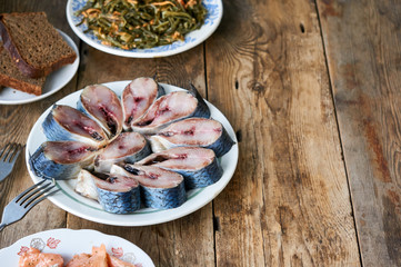 Pieces of salted herring on a white plate