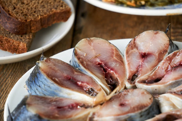 Pieces of salted herring on a white plate
