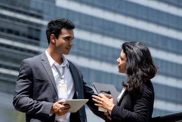 Indian businessman meeting with businesswoman outdoors in the city