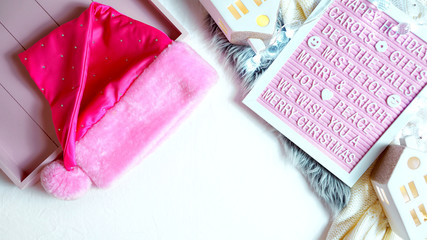 On-trend stylish Christmas flat lay, cozy in bed or indoors wrapping gifts with warm sweater, gifts and letter board with negative copy space.