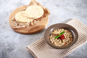 Baked granola with milk and raspberries with mint in a plate, whole grain breads. Healthy breakfast. Delicious muesli.