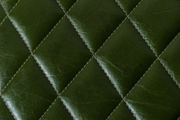 closeup photo of dark green shiny color leather upholstery furniture have stitches square cool mark for background texture abstract