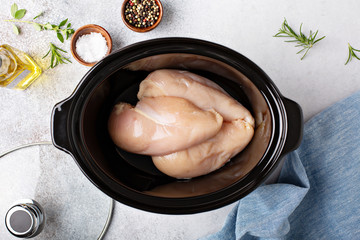 Raw chicken breast in a slow cooker ready to be cooked - obrazy, fototapety, plakaty