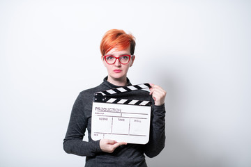 redhead woman holding movie  clapper on white background
