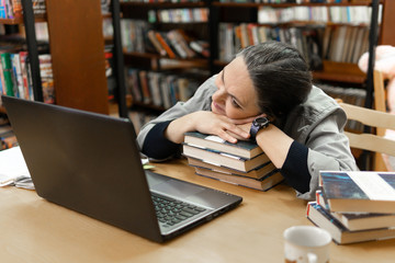 woman in the library in front of bookshelves. Concept of education