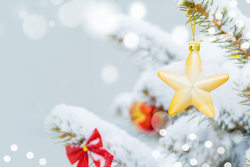 Christmas tree in snow background. New Year composition with fir tree, balls and lights and bokeh.