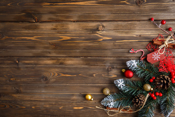 Fir branch with Christmas decorations on old wooden brown background with copy space for text