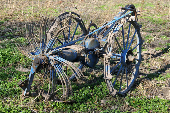 close-up of old hay tedder on field