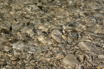 Blurred pebbles underwater in a river in Provence. South of France.